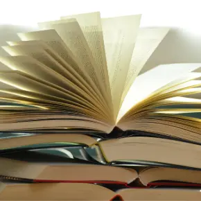 Stack of open books with the top one having its pages spread up
