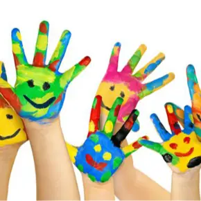 Students hands with the palms painted many colors with smiley faces