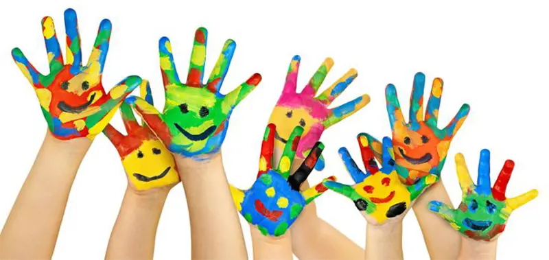 Children with painted hands with smiley faces on them