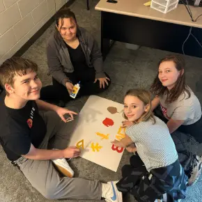 Four students creating a poster together.