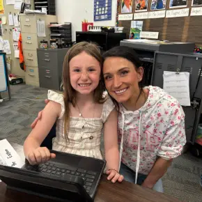 A parent and their student smiling at the camera.
