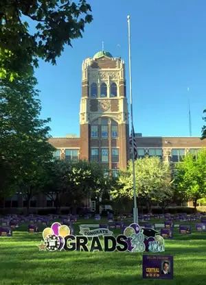 Front of Central High School with a sign saying "Grads" (Graduates)