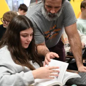 Teacher instruting a student with textbook