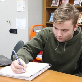 Student writing in notebook