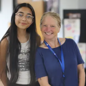 Student and staff member smiling