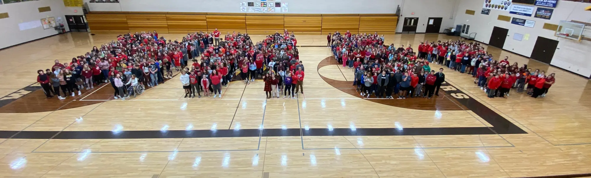 Students on the gym floor forming the letters "WMS"