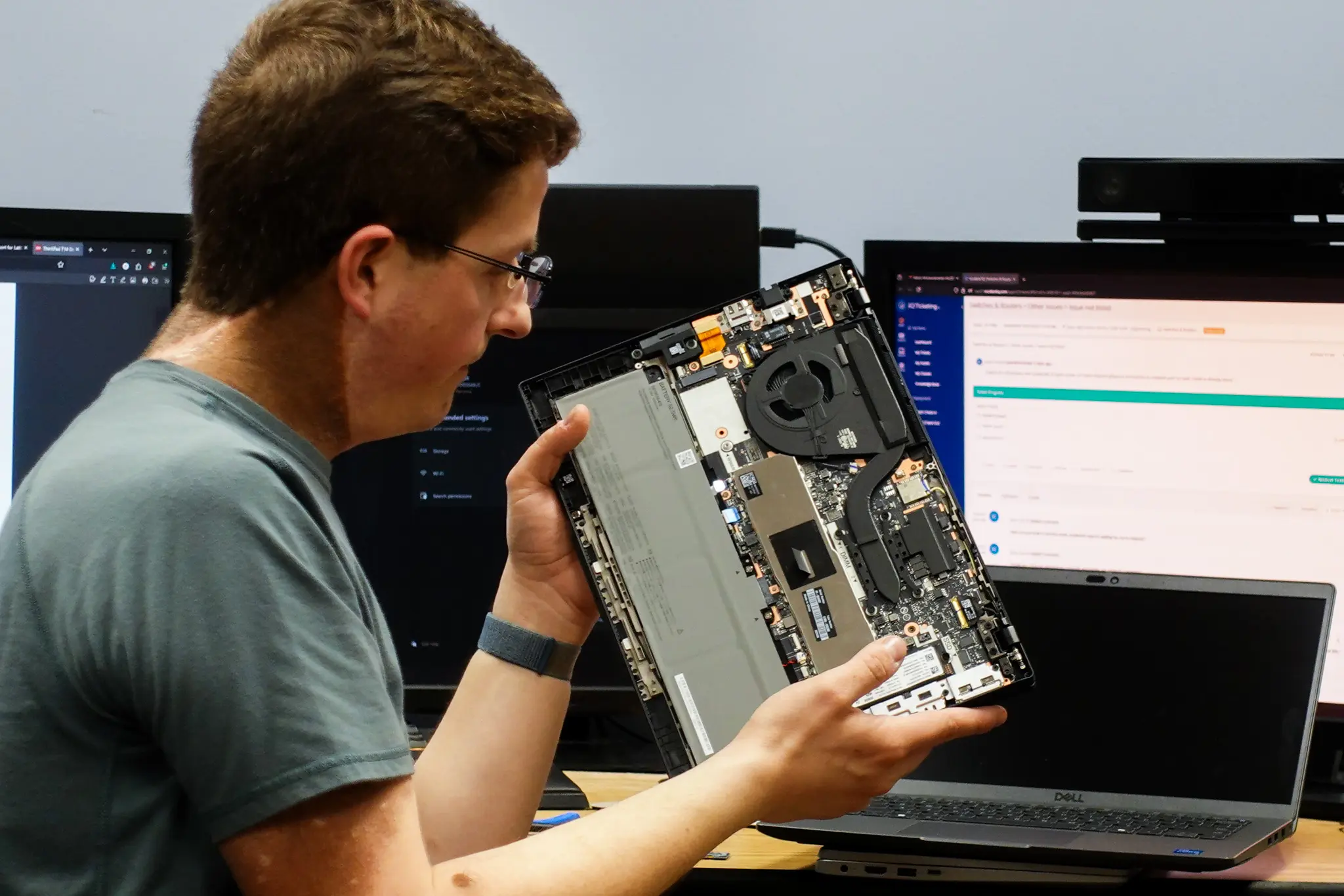 IT staff inspects a new computer before issueing it to a staff member