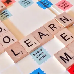 Scrabble Board with the word "LEARN" spelled out in letter tiles