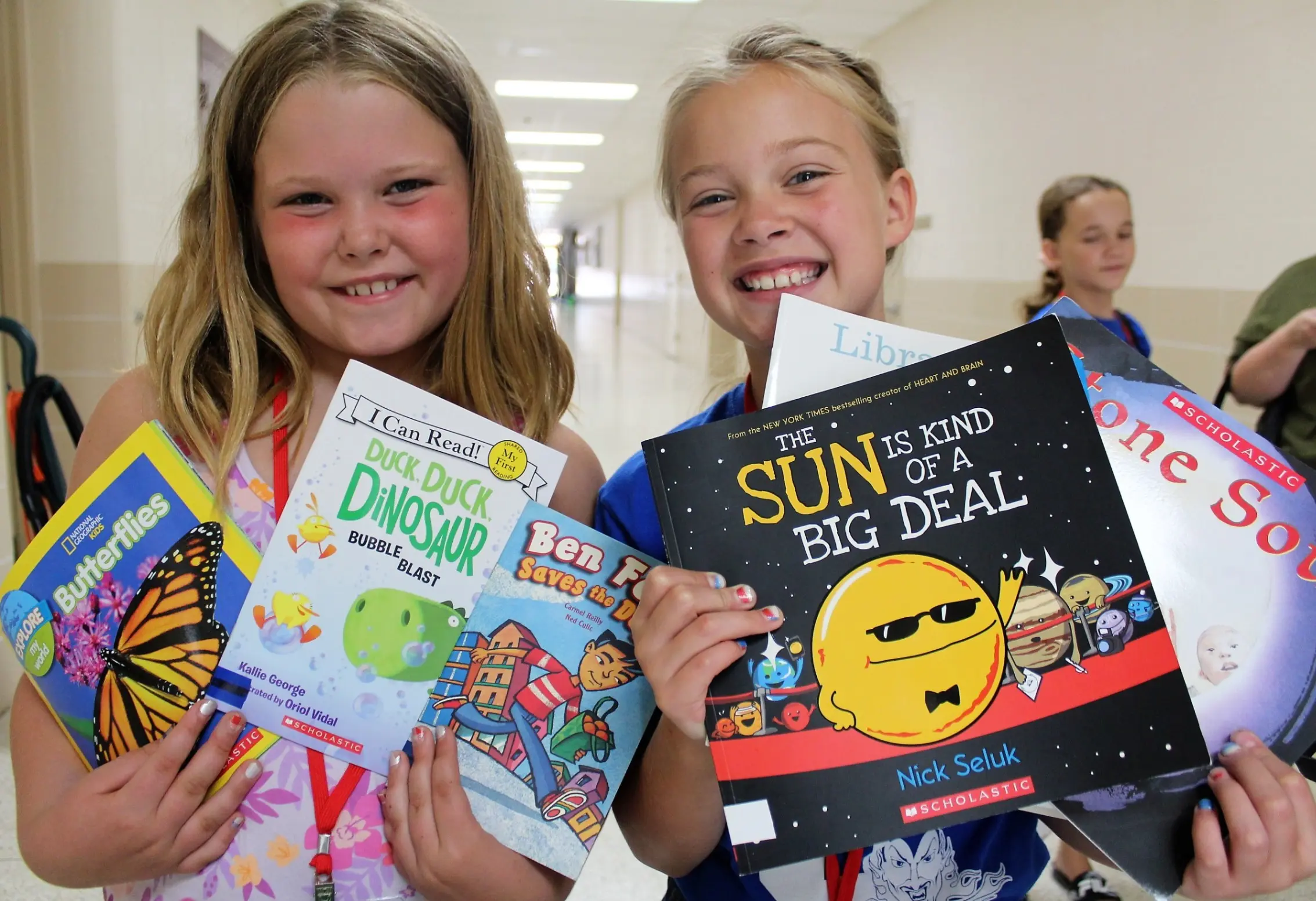 Two students holding up books