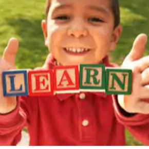 young student with block letters in his hands