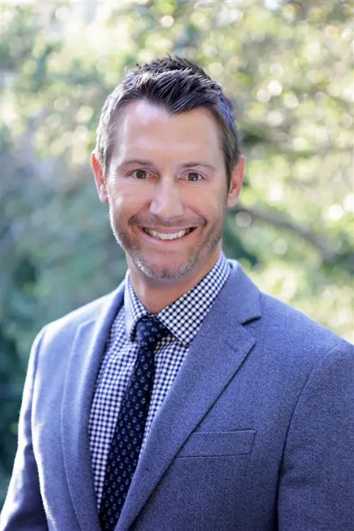 Headshot photo of Dr. Brett Heithman; wearing a suit, shirt and tie
