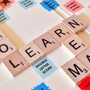 Scrabble Board with the word "LEARN" spelled out in letter tiles