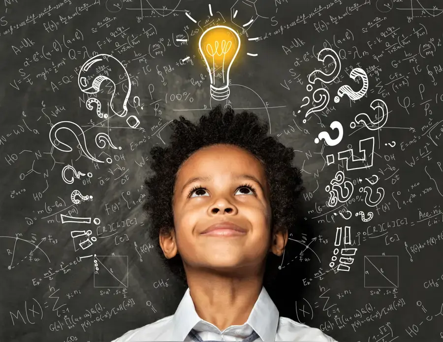 Student with a chalkboard background with a light bulb that is "on" drawn on top of the students head. 