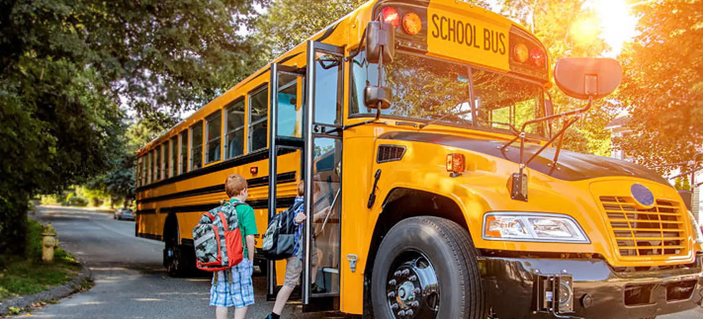 students getting onto school bus