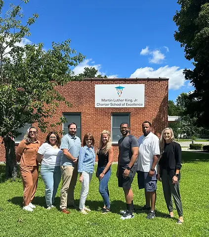 Members of the Board of Trustees in front of the school
