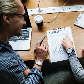 two woman looking at a contract form.